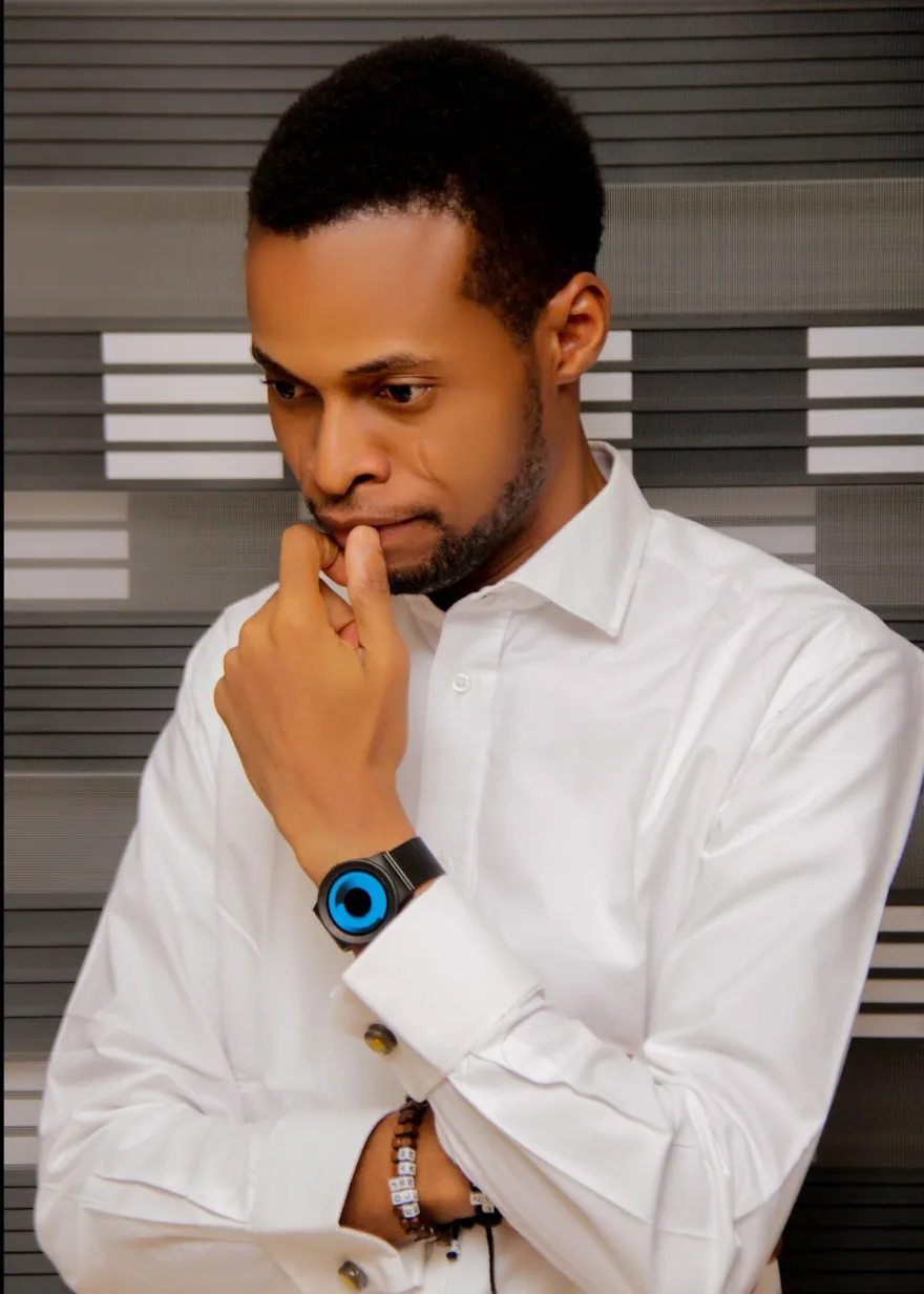 Oluwaseyi Ashiru in a white shirt, hand to his chin, deep in thought